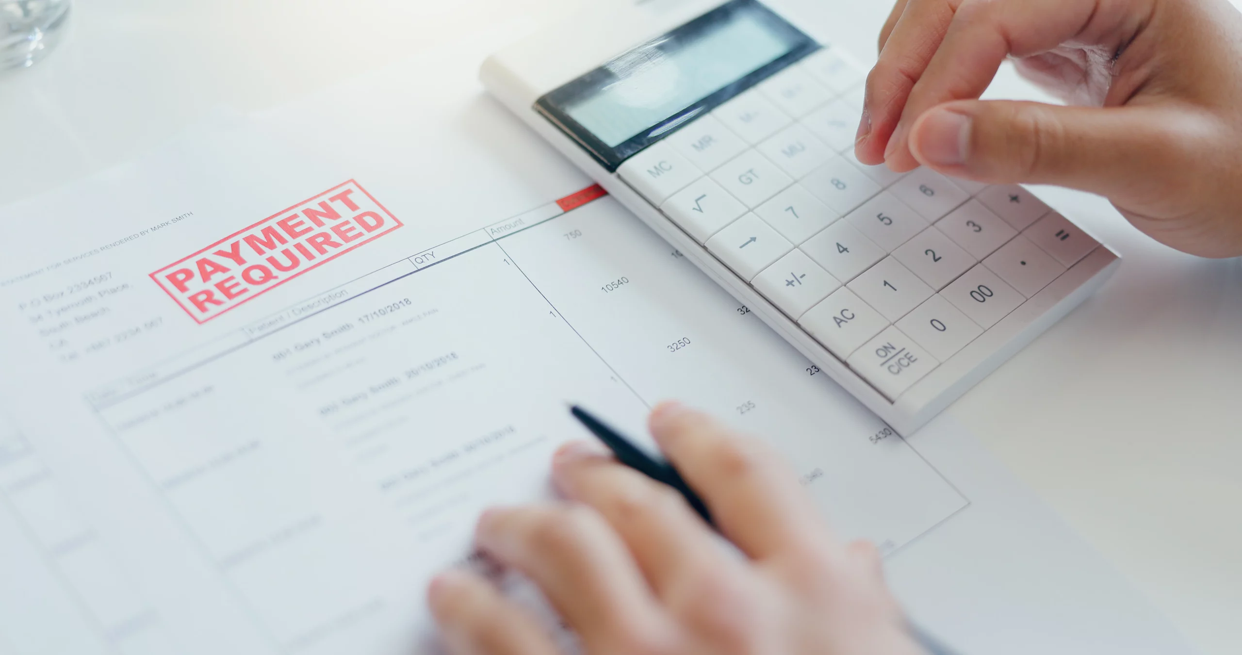 Person calculating Chapter 13 bankruptcy payment plan modifications while reviewing required payment documents and financial obligations.